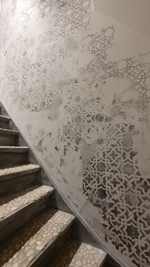 Treppenaufgang mit grau-weißem geometrischem Wandmuster