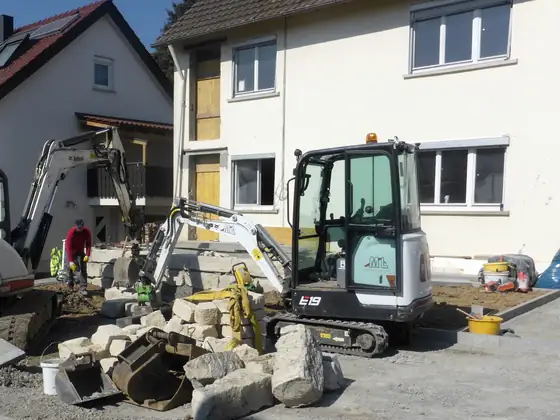 Haus während der Sanierung mit Baggern im Vorgarten
