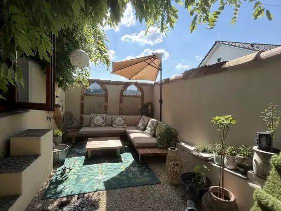 Innenhof nachher mit Lounge, Pflanzen und Sonnenschirm