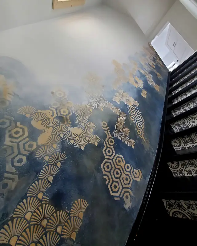 Treppenwand in Dunkelblau mit goldenen Fächer- und Wabenmustern